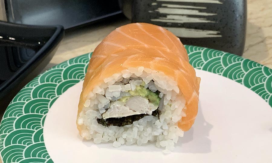 Slo rolls simples llegan en la barra de sushi giratoria