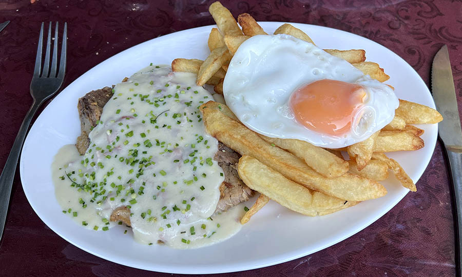 Pierna de cerdo al horno con salsa, papas fritas y huevo frito