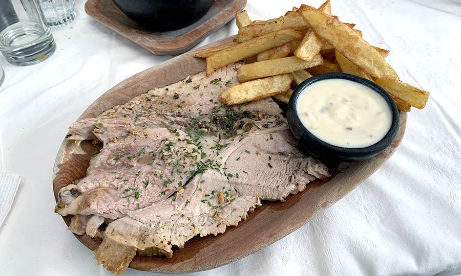 Pierna de cerdo al horno con salsa aparte y papas fritas