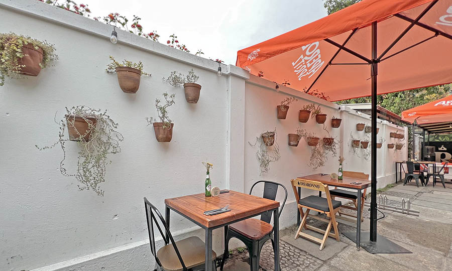 Las mesas en el patio al entrar a Raffaella Pizza